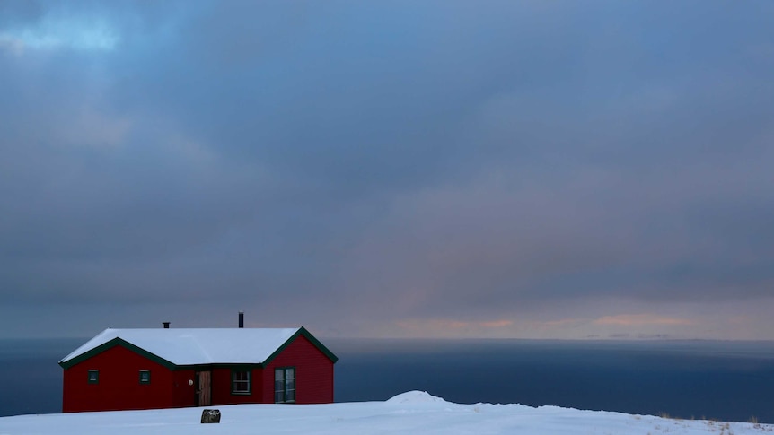 A house overlooks the ocean on the isolated archipelago of Svalbard, deep in the Arctic Circle.