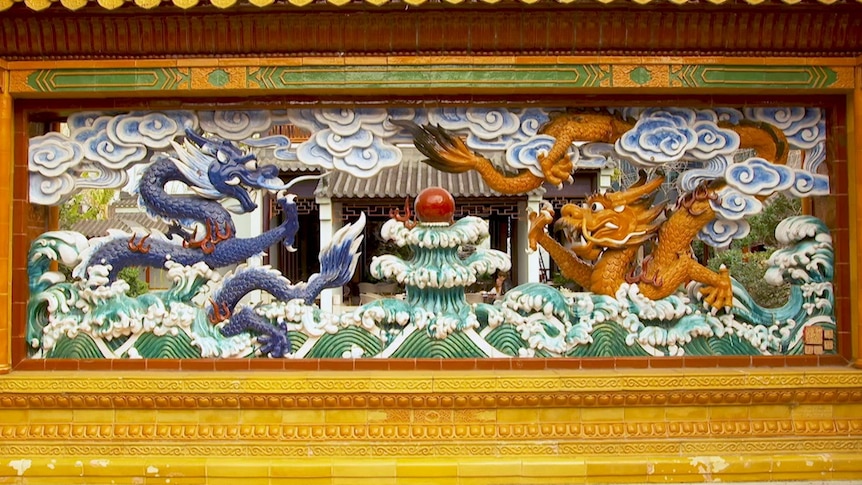 Ceramic artwork with dragons, clouds and waves in Chinese garden in central Sydney