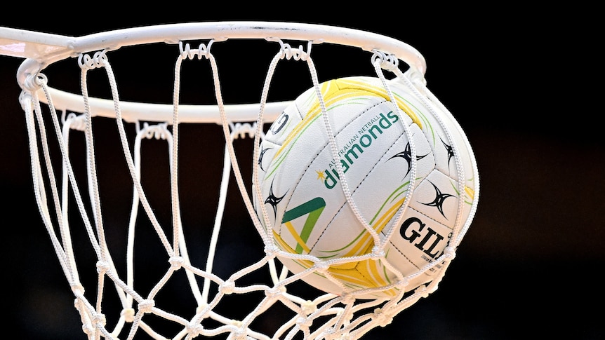 A close-up picture of a netball net bulging with a ball inside it.