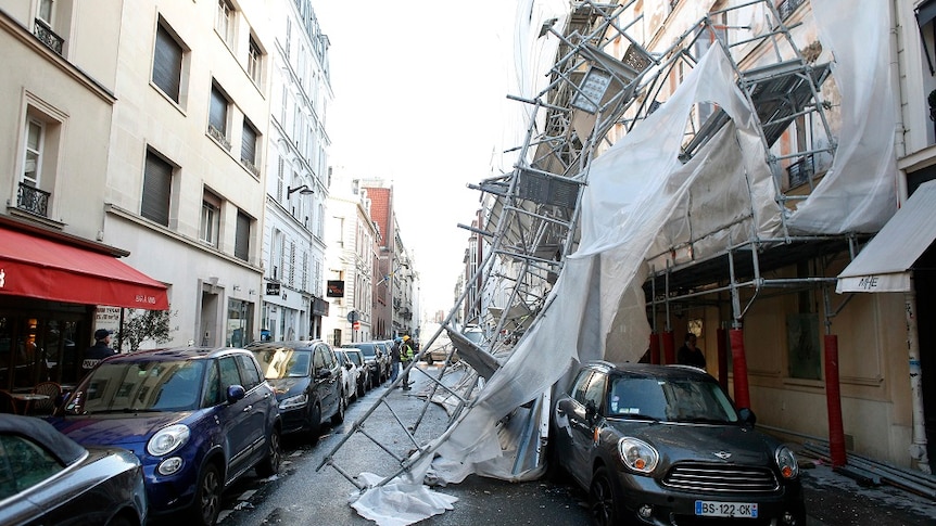 Collapsed scaffolding rests on parked cars in Paris.
