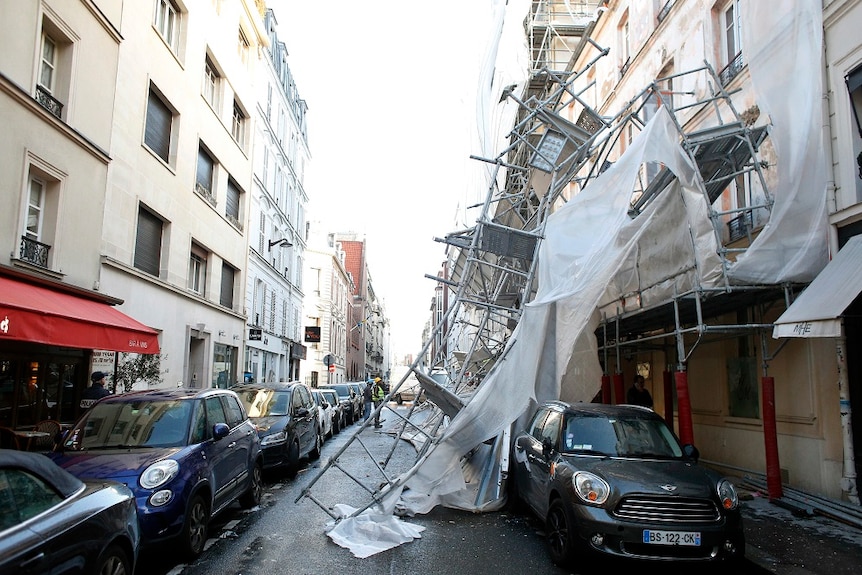 Collapsed scaffolding rests on parked cars in Paris.