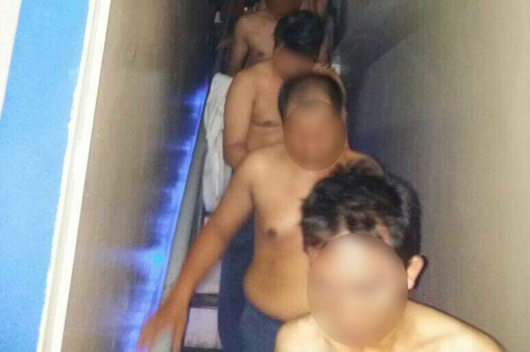 A group of shirtless men walk down stairs during a police raid on a gay club in North Jakarta on May 21, 2017.