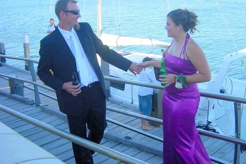 A man holding a woman's hand on a jetty.
