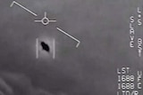 A grainy greyscale image shows a disc-shaped blob moving through the air, being picked up by a jet tracking system.