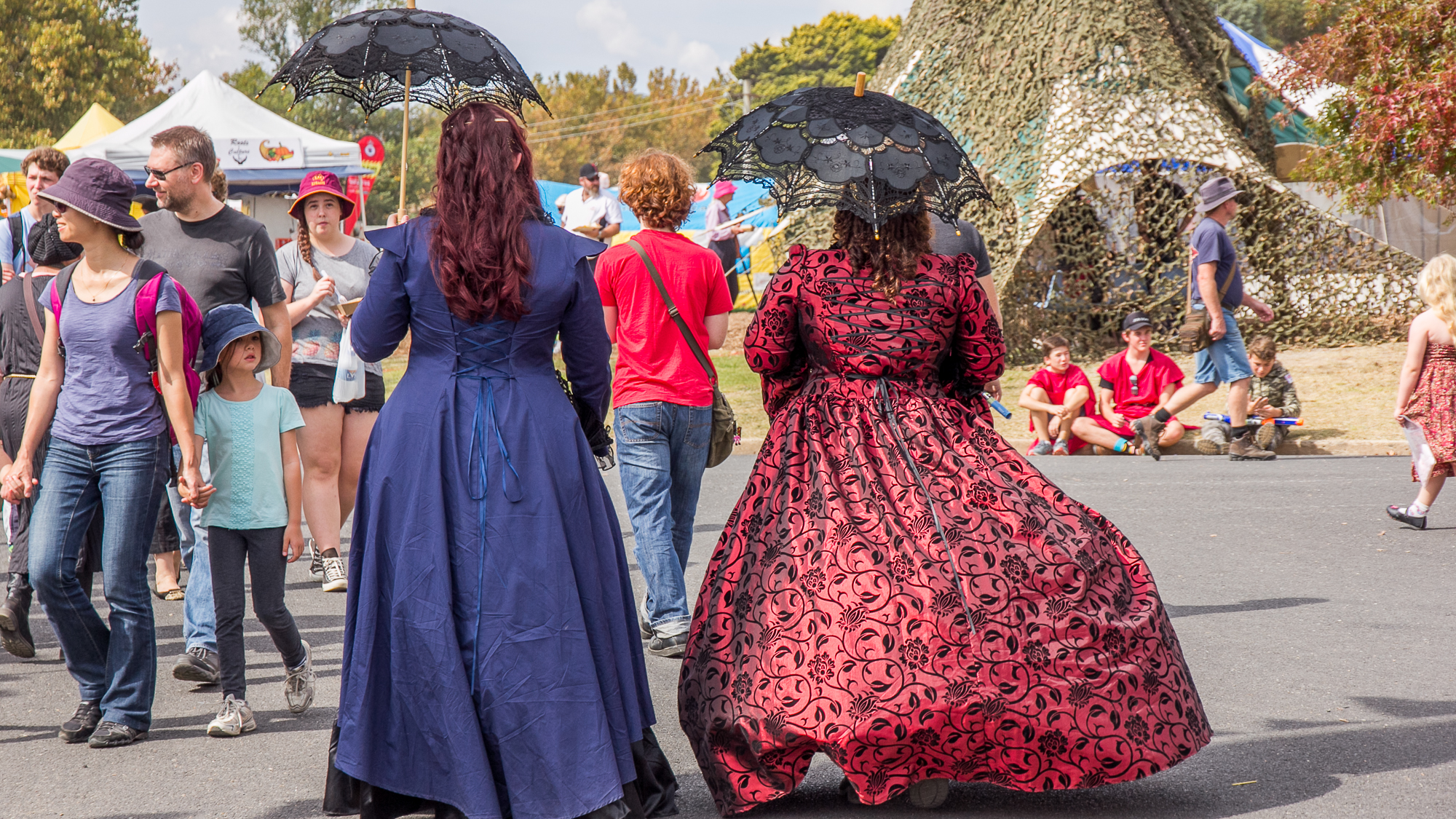 Backs of women with lace parasols and big dresses laced at the back