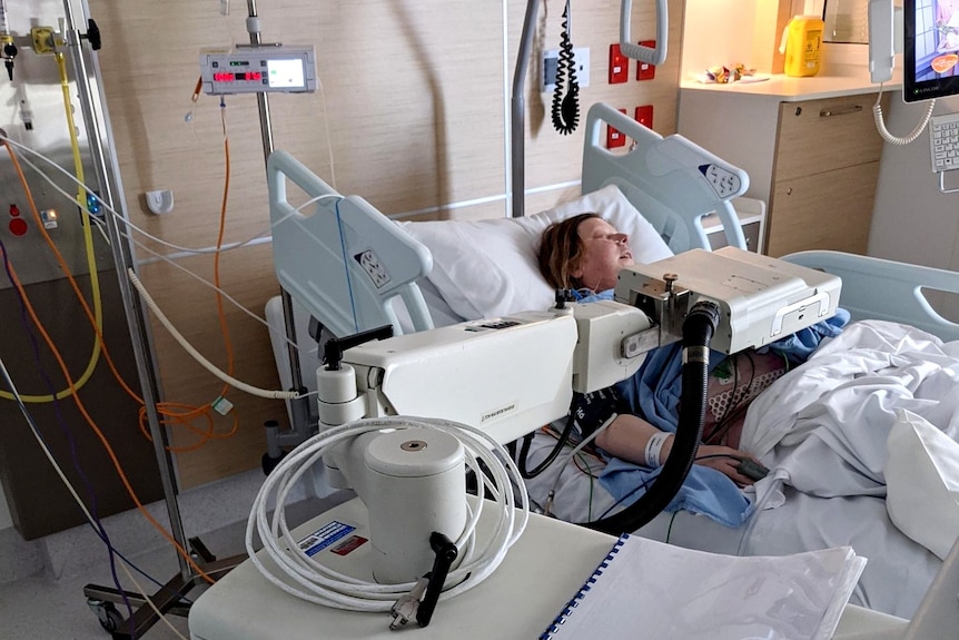 Woman lies in hospital bed