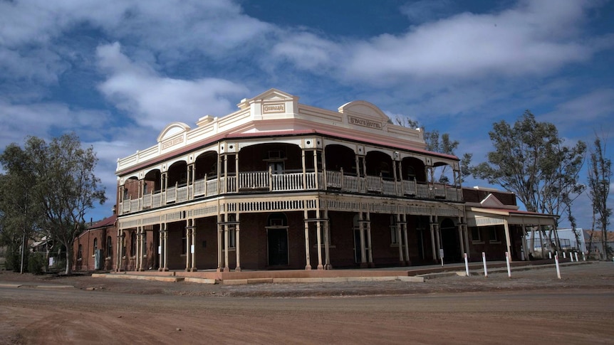 Gwalia State Hotel, a two-story brick building with 10ft.  balcony wrapped around the facade. 