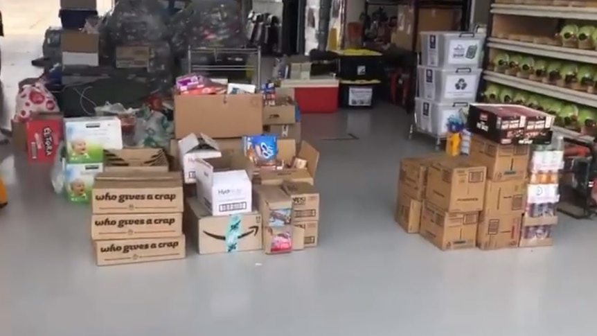 The floor of a fire station covered with donated foods and goods.