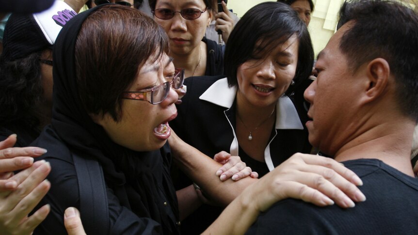 A Lehman Brothers mini-bonds holder cries as she is comforted by other protesters.