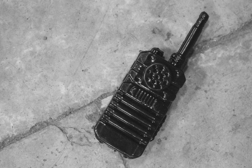A black and white image of a walkie talkie on the floor