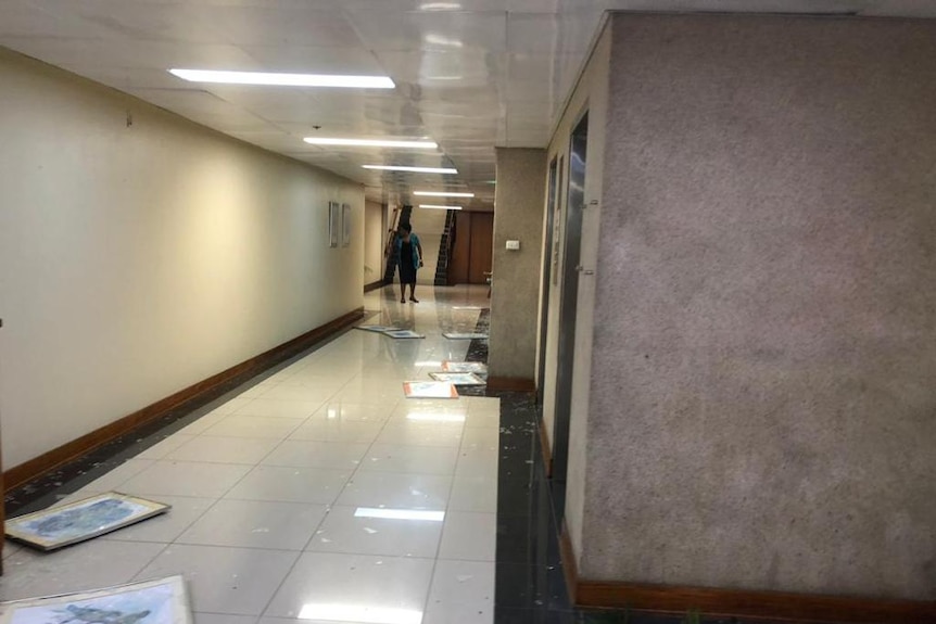 Art and shattered glass strewn about a hallway at PNG Parliament on November 20, 2018.