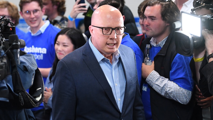 Dutton walks through a crowd wearing Liberal blue shirts.