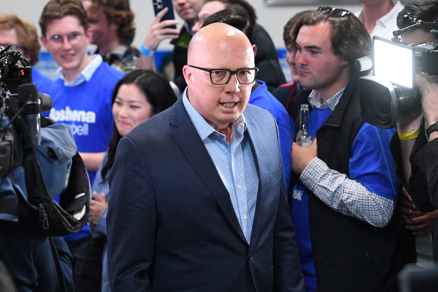 Dutton walks through a crowd wearing Liberal blue shirts.