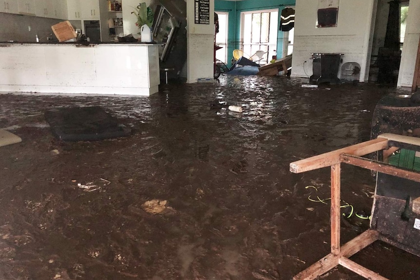 Flood-damaged lounge and kitchen in a house at Bluewater