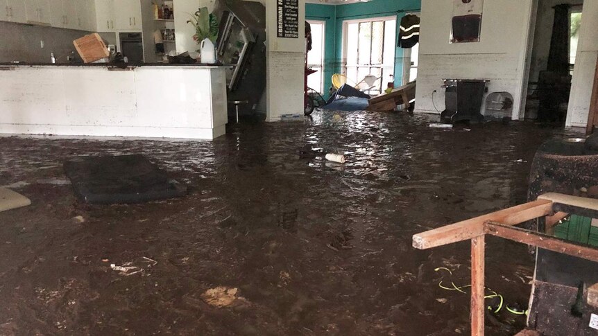 Flood-damaged lounge and kitchen in a house at Bluewater