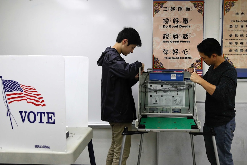 Volunteers Leandro Wong, left, and Matthew Morita set up a polling booth at Hsi Lai Temple on November 6, 2018, in California.