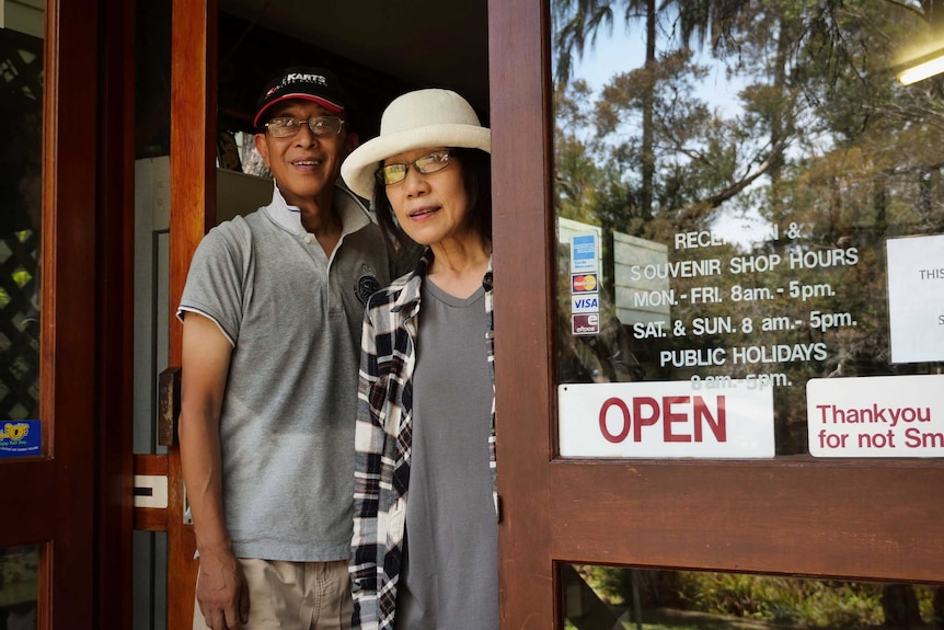 Eco-resort owners Joe and Wen Zhu standing inside reception, looking out into the rainforest.