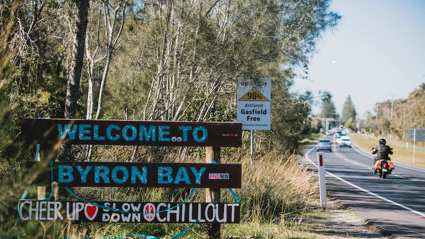 A welcome to Byron Bay sign aslo reads Cheer Up Slow Down Chillout