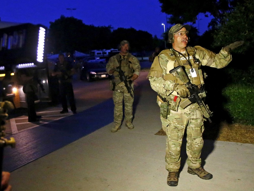 Police officer directs people at scene of shooting at the Muhammad Art Exhibit and Contest in Texas