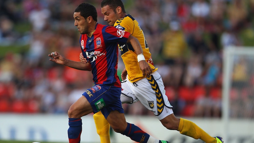 Ali Abbas running forward with the ball chased by Mariners defender