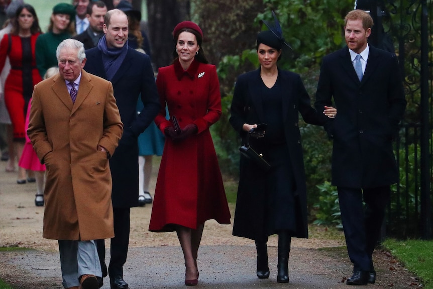 King Charles, Prince William, Kate, Prince Harry and Meghan walk together.