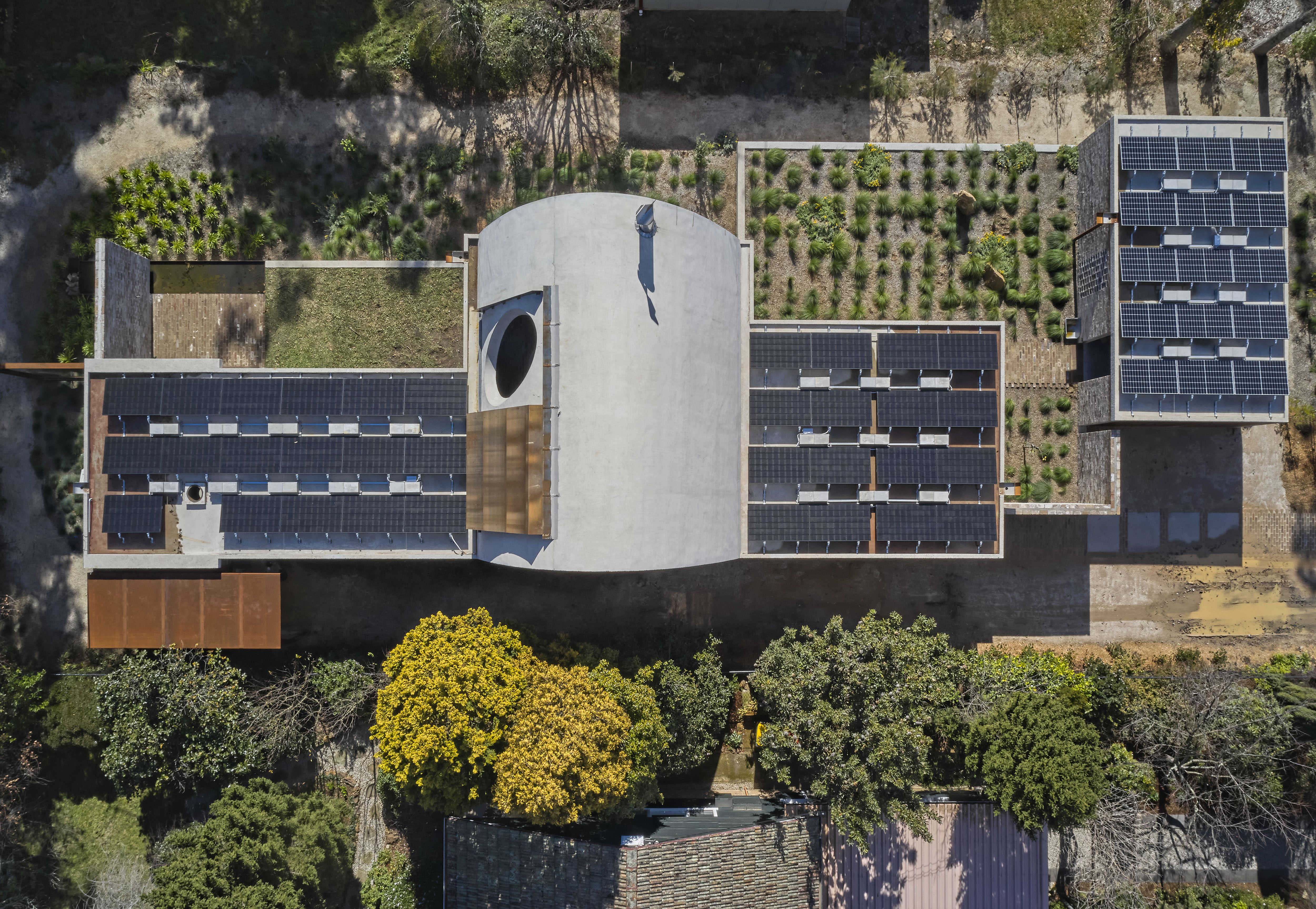 An aerial view of a house with solar panels on the roof.