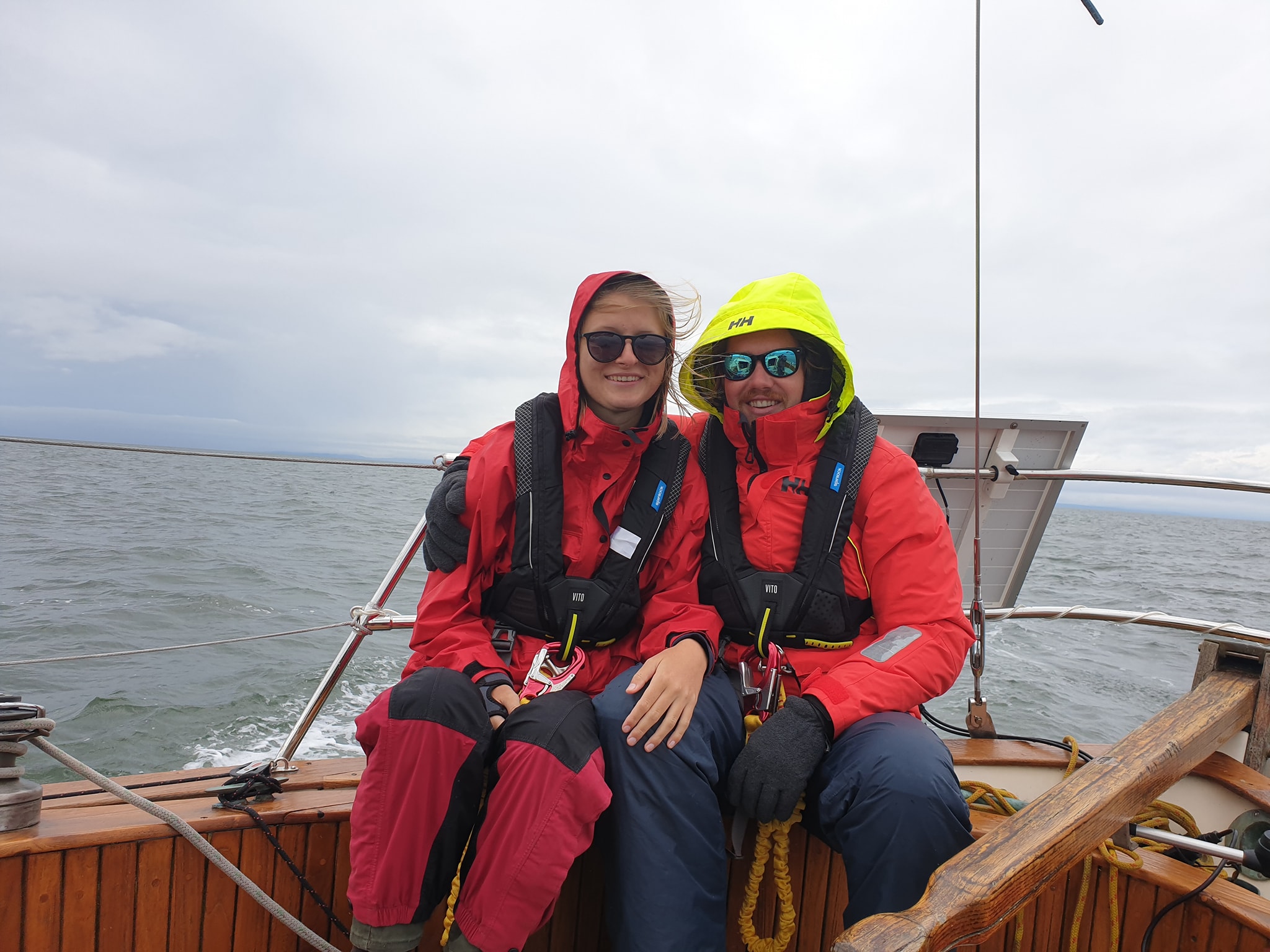 people in rainwear on a boat smiling