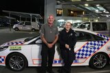 Sergeant Megan Ward and clinical nurse consultant Simon Daniels stand next to a police car.