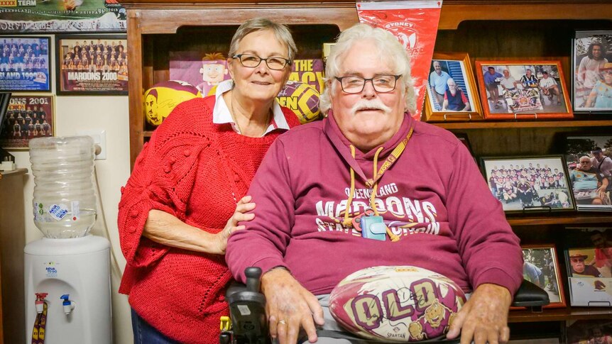 A couple sitting in front of maroons memorabilia.