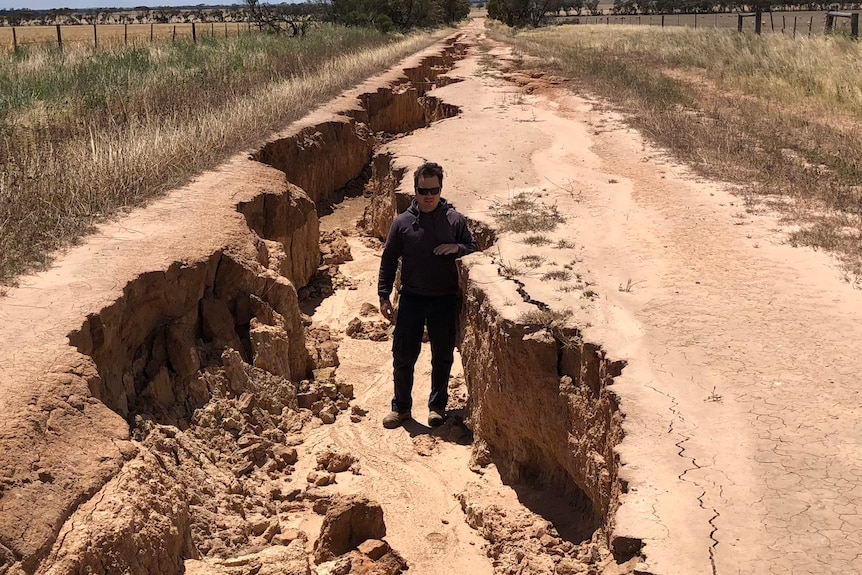 Matt Rohde stands in the damaged road