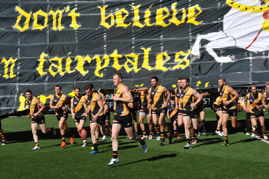 Richmond players run onto the field for the elimination finals match with Port Adelaide.