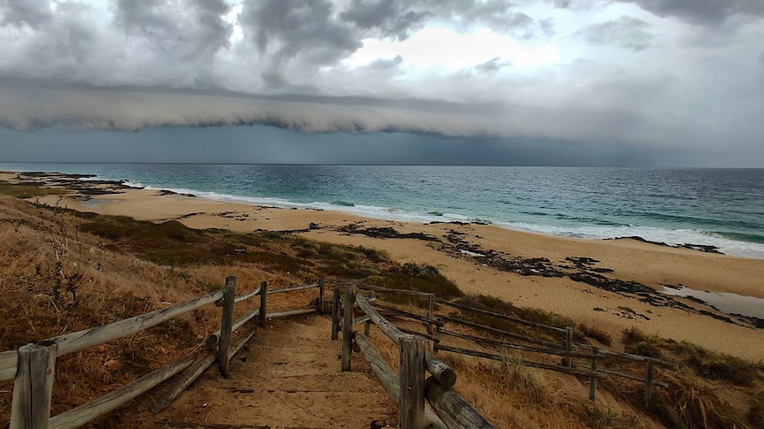 A cold front over the ocean, with a photo taken from the beach.