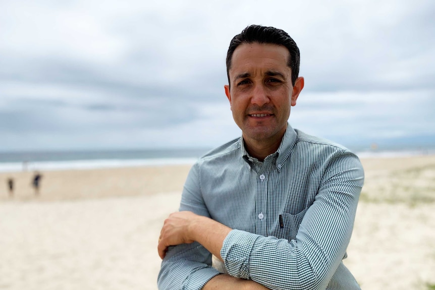 man at beach, cross armed, smiling