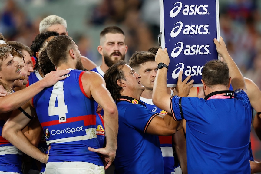 Luke Beveridge points to a whiteboard while speaking to Bulldogs players