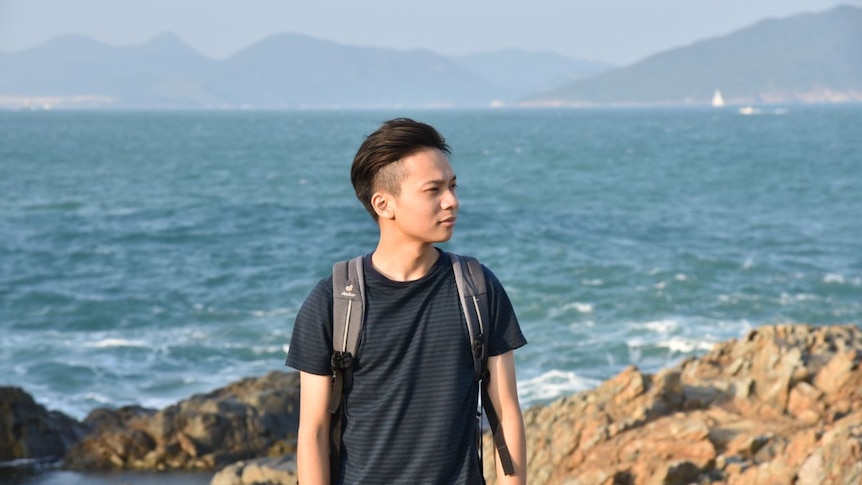 Arthur Yeung stands in front of a body of water.