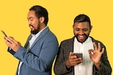 Photo of Matt Kerr and Shahmen Suku interacting on their phones, they experience racism via gay dating apps like Grindr