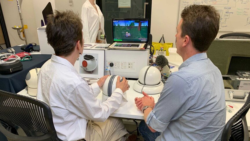 Two researchers stare at a computer screen