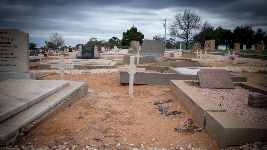 An unmarked grave between two graves with headstones in the old section of the Barmera cemetery.