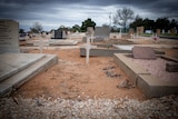 An unmarked grave between two graves with headstones in the old section of the Barmera cemetery.