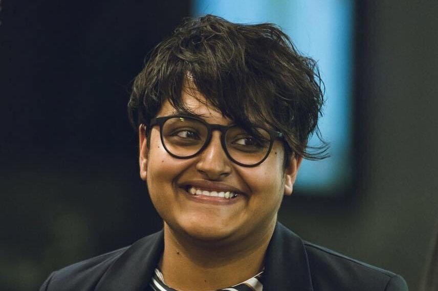 A close-up of an Indian woman in glasses smiling.  