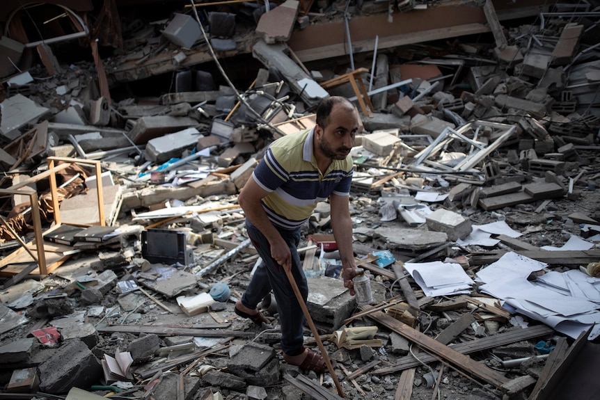 A Palestinian man inspects the damage of a house destroyed by an early morning Israeli airstrike in Gaza City