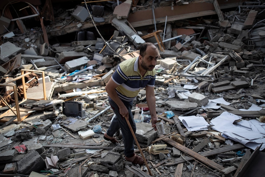 A Palestinian man inspects the damage of a house destroyed by an early morning Israeli air strike in Gaza City