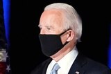 Joe Biden walks out for his acceptance speech wearing a mask after winning the US presidential election