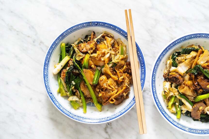 A bowl of thick rice noodles served with gravy and vegetables, a vegetarian family dinner by Hetty McKinnon.