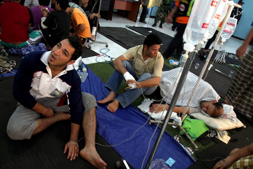 Survivors of a boat sinking off Indonesia en route to Australia are treated at a temporary shelter.