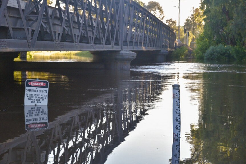 Signs submerged in river, levels high on gauge