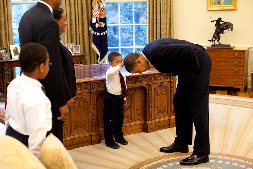 A White House staffer's son touches Barack Obama's head in the Oval Office