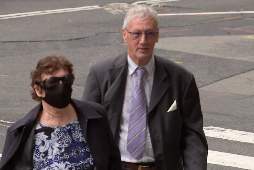 A man and woman walk side by side up some steps