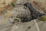 A section of highway buckled by a sinkhole.