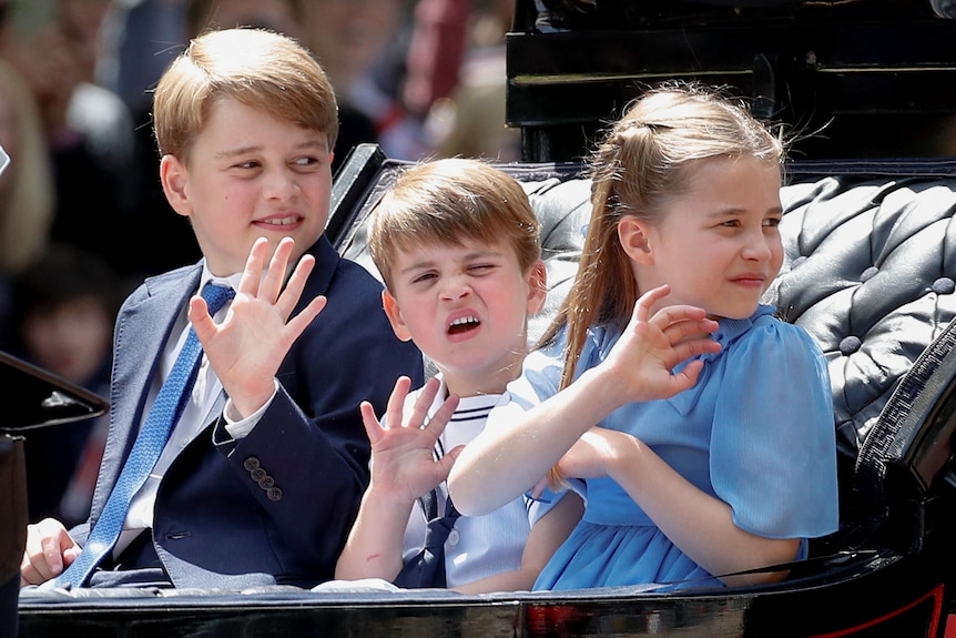 Britain's Prince George, Prince Louis and Princess Charlotte ride in a carriage